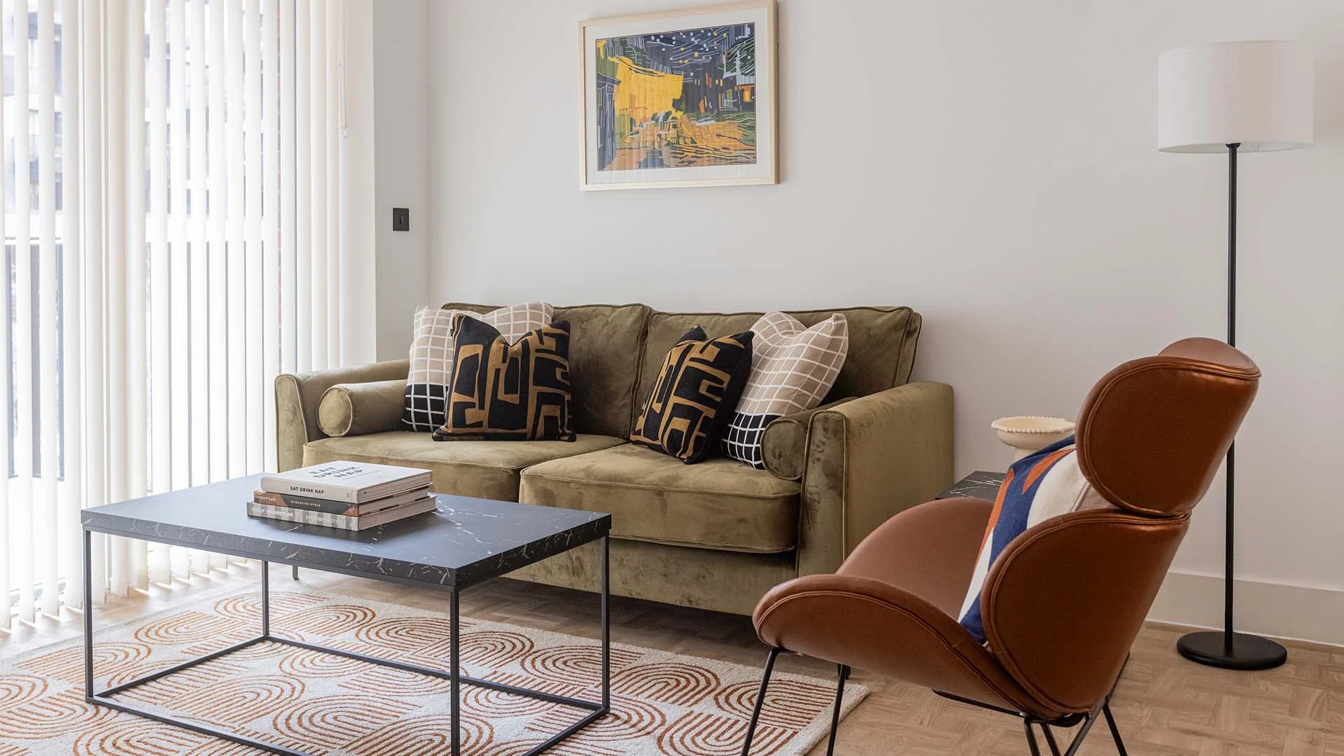 Contemporary living room interior with velvet sofa, accent chair, and minimalist decor
