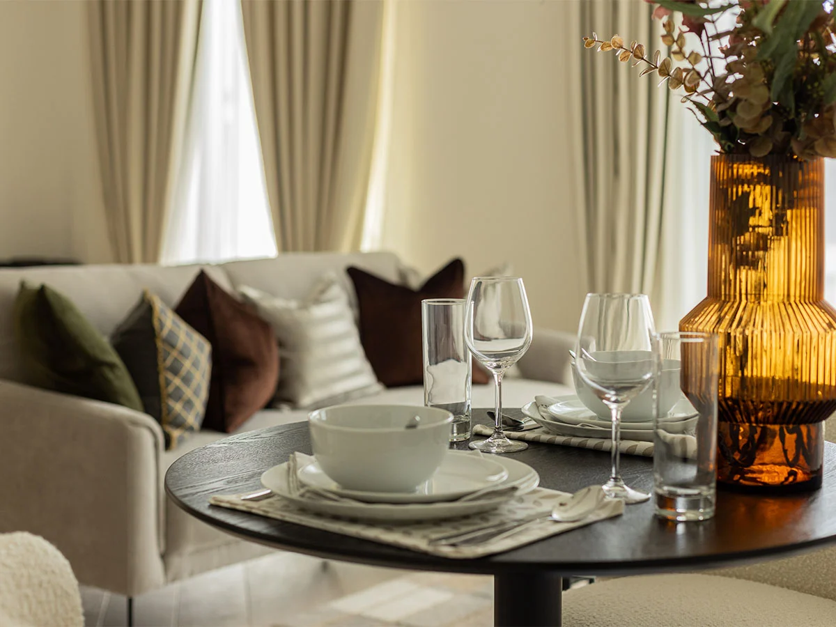 dining table with glasses and sofa with cushion of Pembridge Gardens, Notting Hill