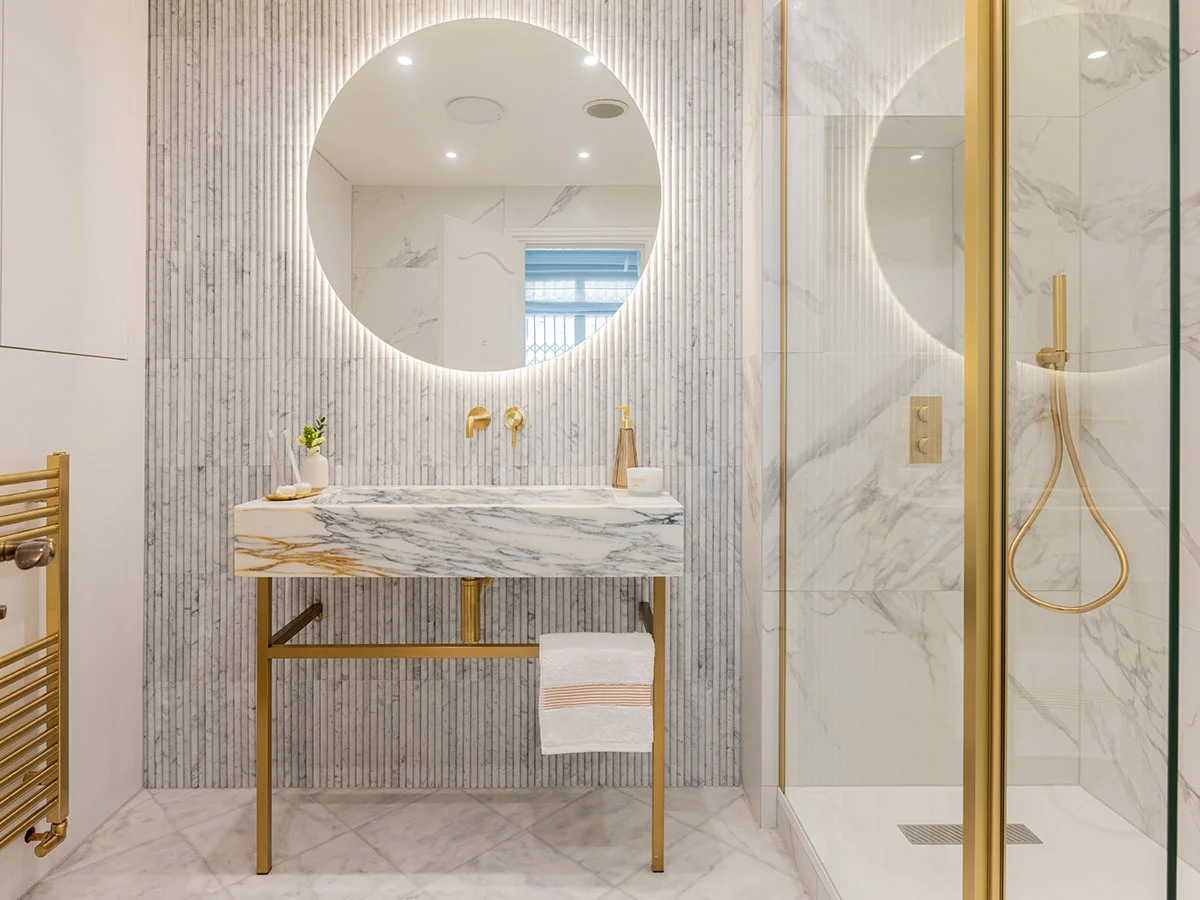 High-end bathroom transformation featuring marble finishes, brass fittings and contemporary styling