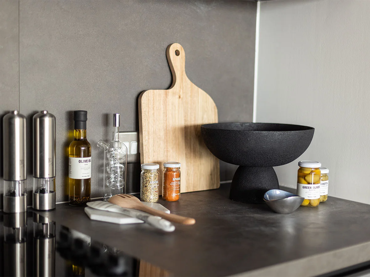 Kitchen counter with olive oil, spices, and serving bowl of Coronation Square