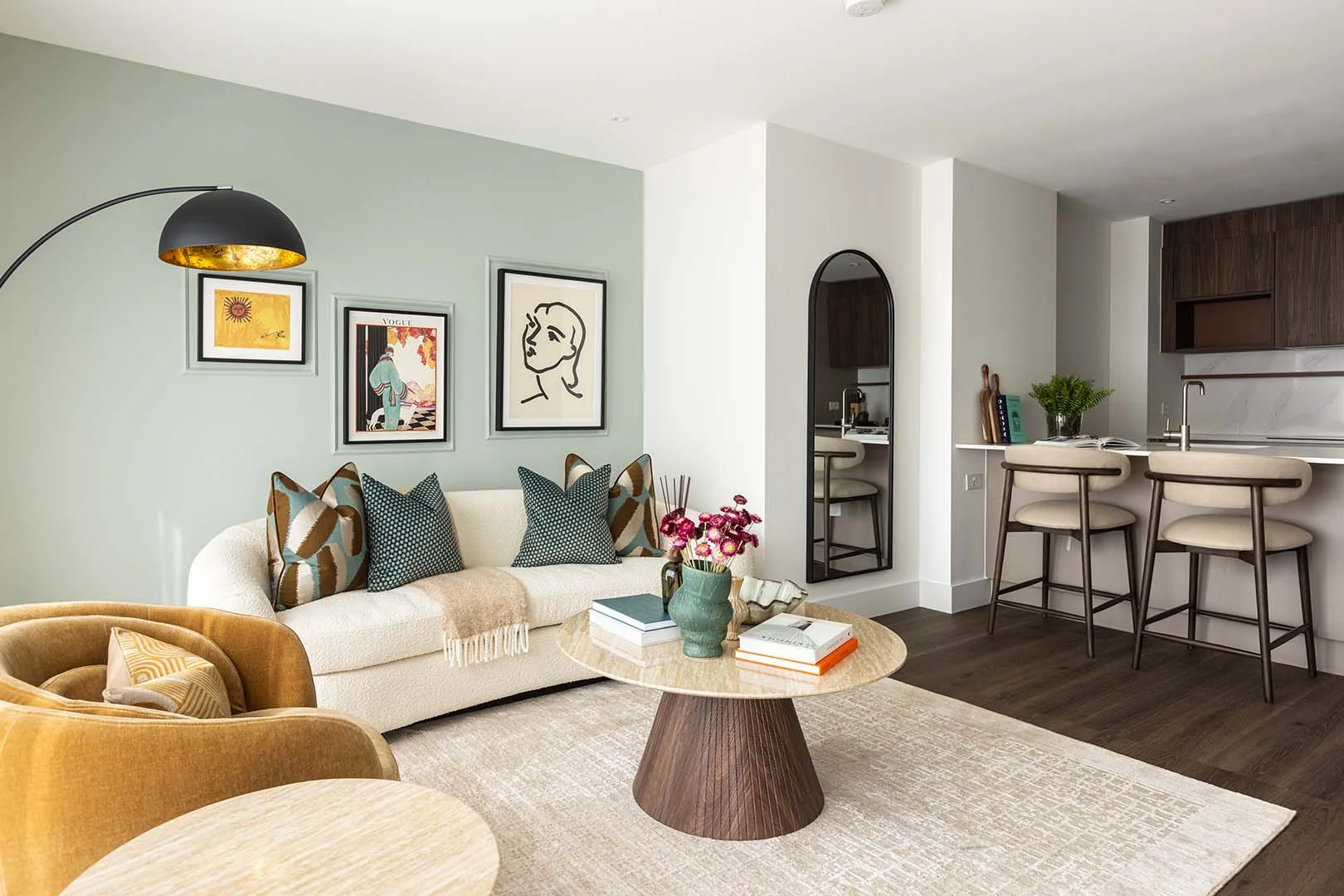 Modern living room interior design in Bow Green East London featuring sofa, wall art and open-plan kitchen
