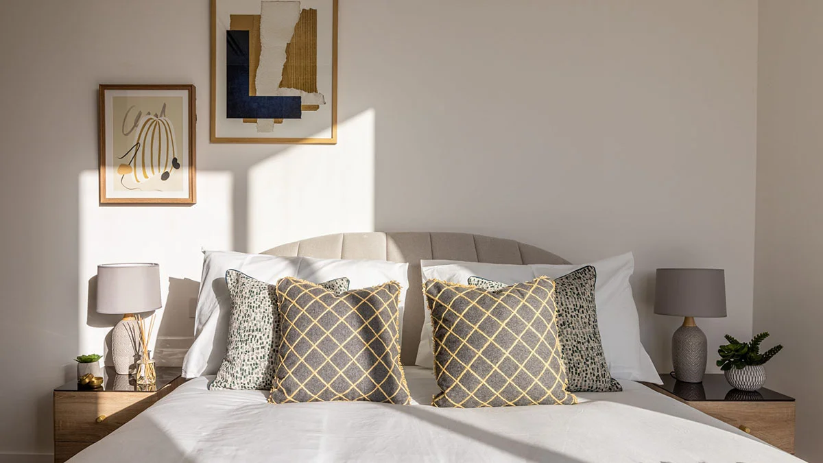 Luxury build-to-rent bedroom with neutral styling and decorative cushions
