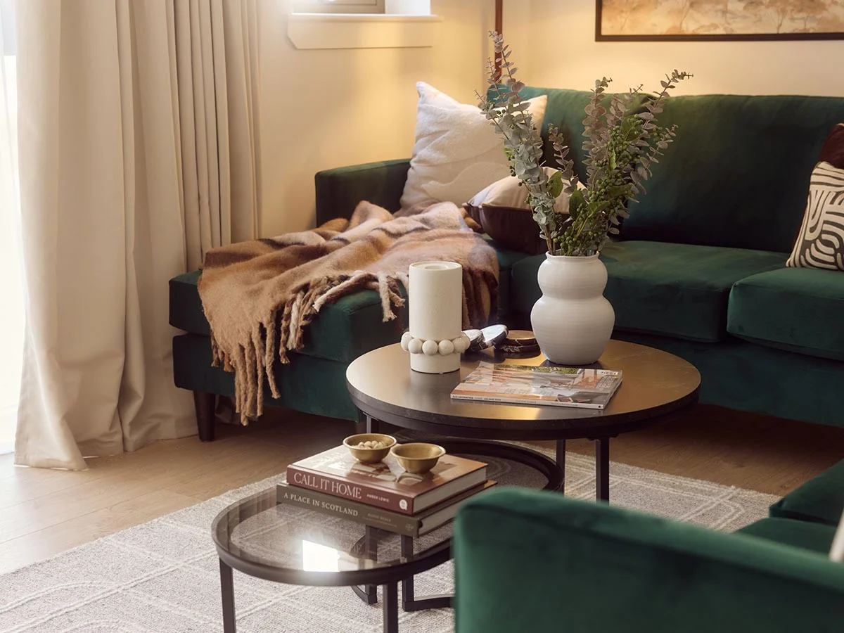 Warm and inviting build-to-rent living room with green velvet sofa and soft lighting