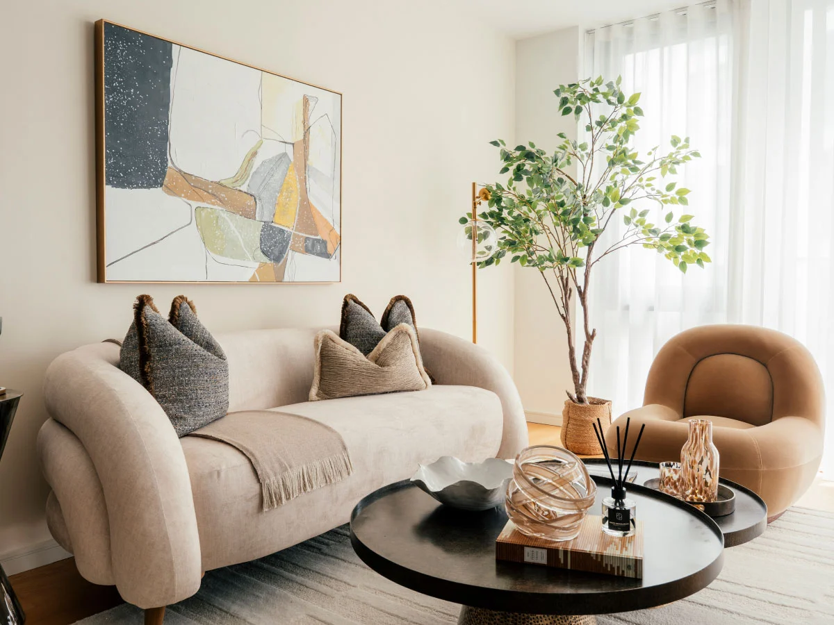 A designer master bedroom at Sugar Island, Stratford, featuring a bold terracotta palm leaf wallpaper, a plush grey headboard, and a modern two-drawer nightstand styled with a marble lamp and minimalist clock