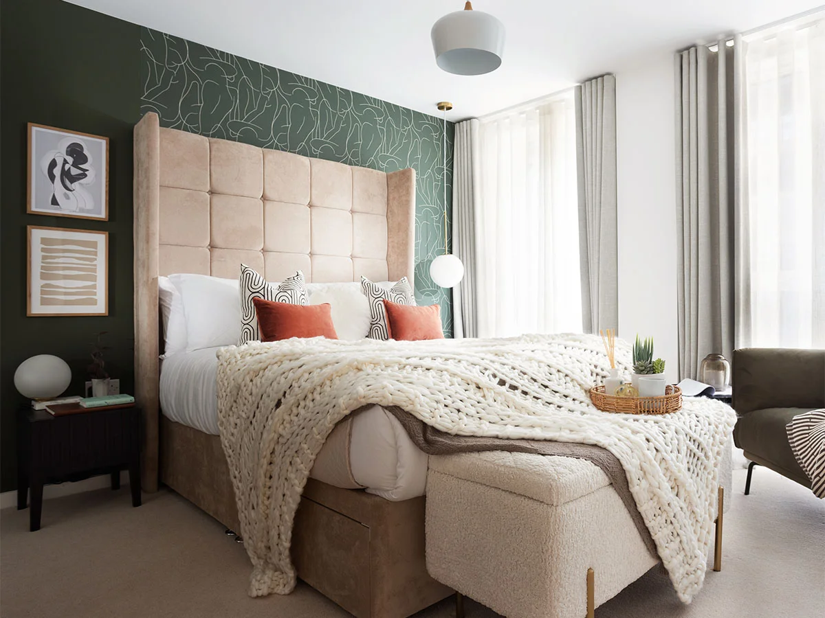 Cozy bedroom with green accent wall and king bed