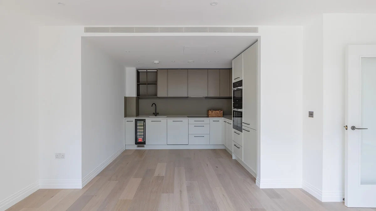 An empty, unfurnished kitchen area in a London flat prior to professional interior design staging.