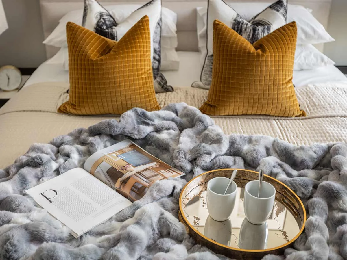 A modern bedroom featuring stylish Furniture Packages, including a cozy bed with layered pillows