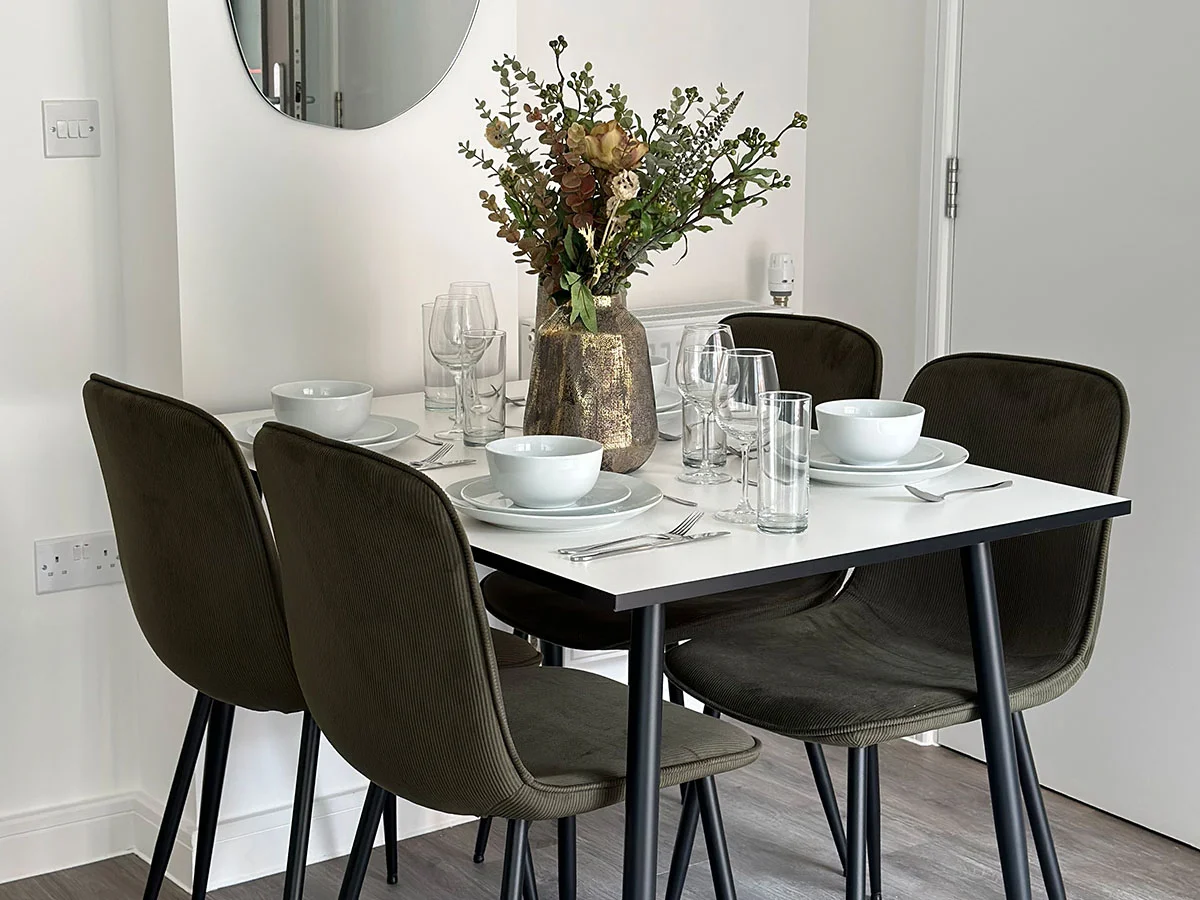 Modern dining table with upholstered chairs, minimalist decor, and stylish lighting in a contemporary apartment