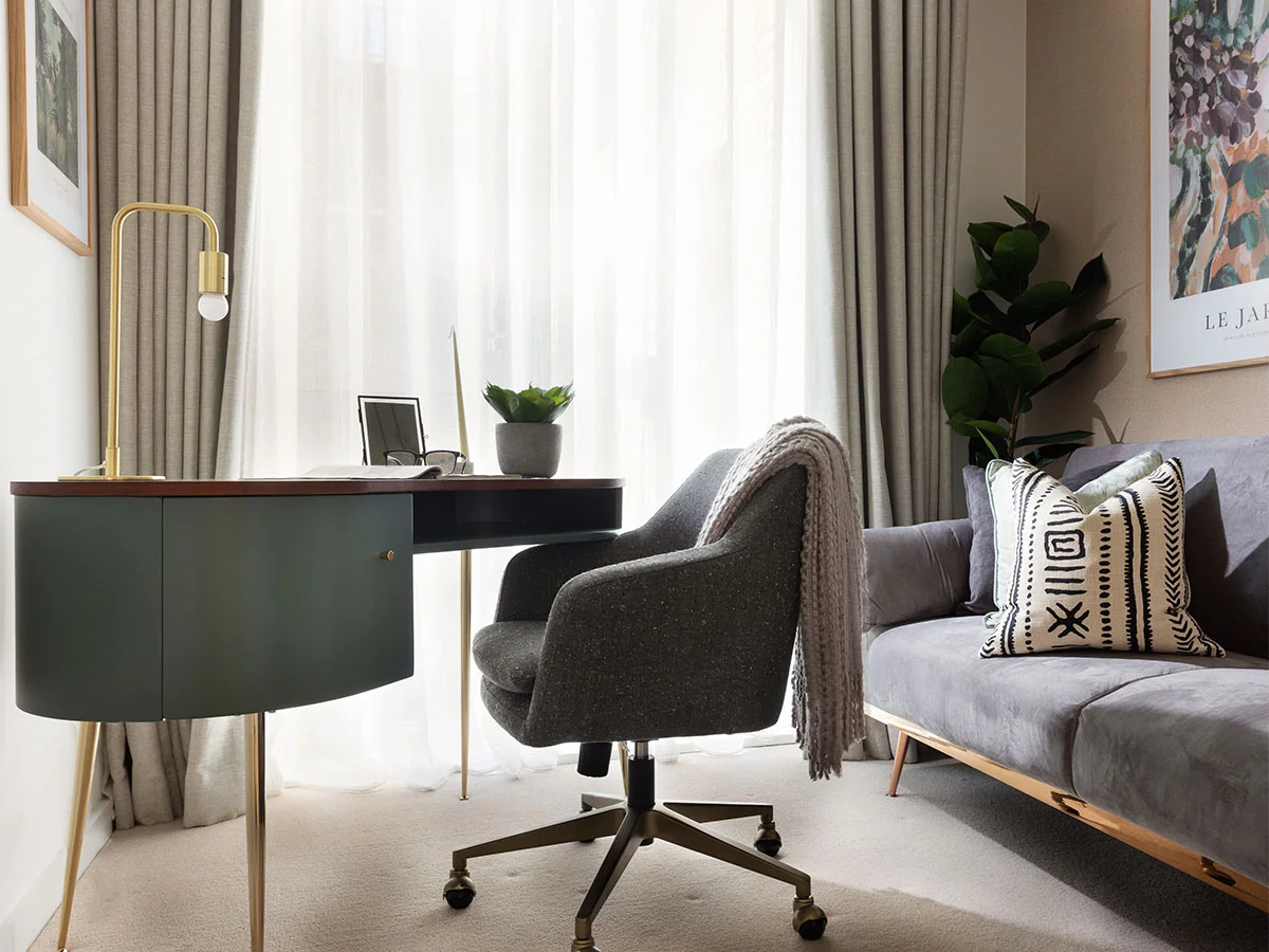 Modern home office with desk, chair, and sofa