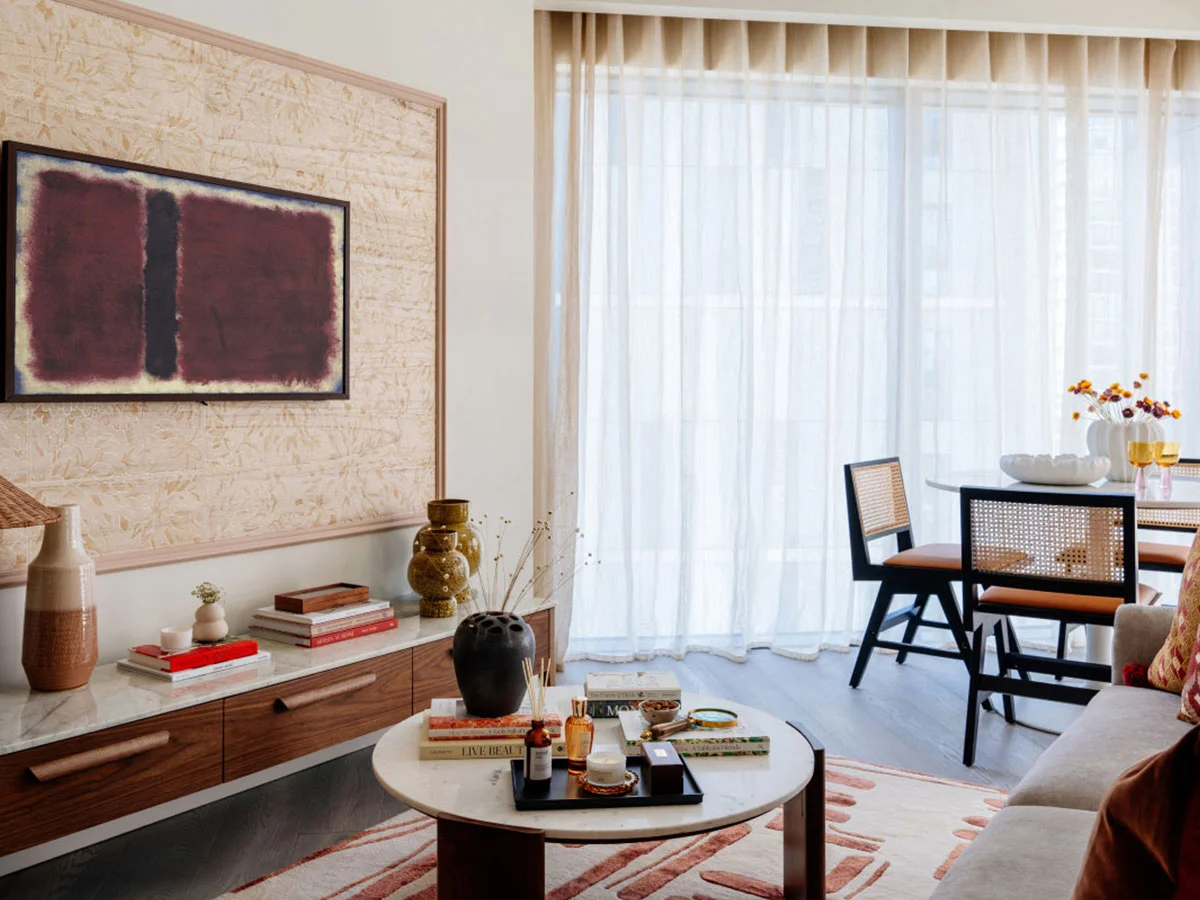 A modern living area professionally styled by InStyle Direct featuring a white marble-topped coffee table, dark wood canework dining chairs, and warm wood-effect flooring in Greenwich