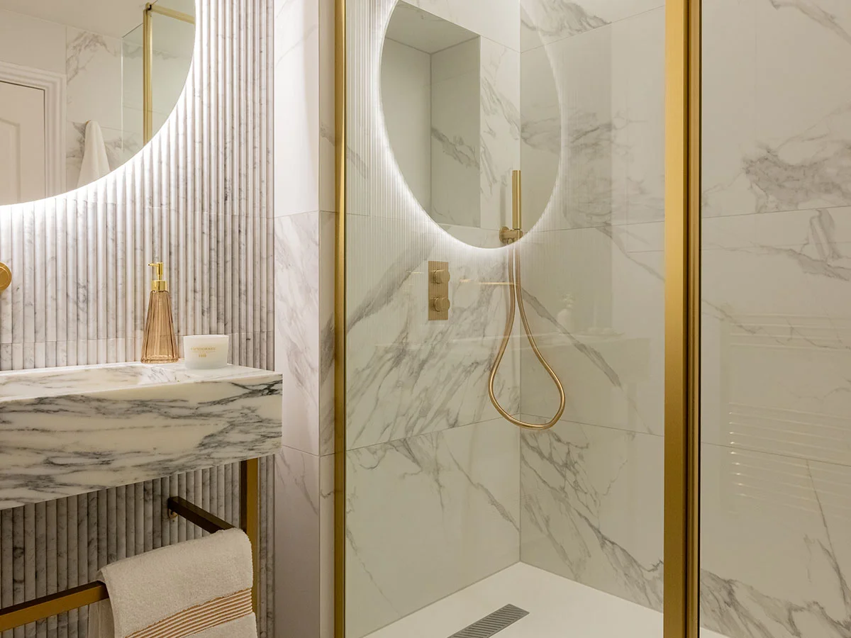 Contemporary bathroom with green tiled wall and brass fittings creating a bold modern look
