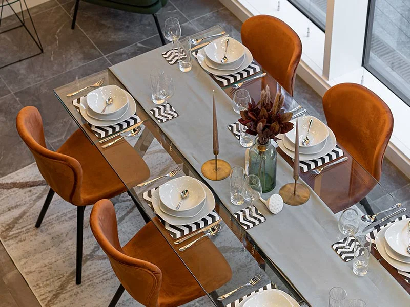 A chic arrangement of abstract art, a modern mirror, and decorative accents styled with thoughtfully curated show homes furniture