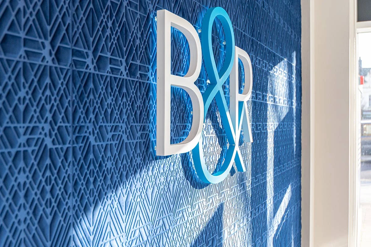 Office interior feature wall with branding logo and textured blue panel design