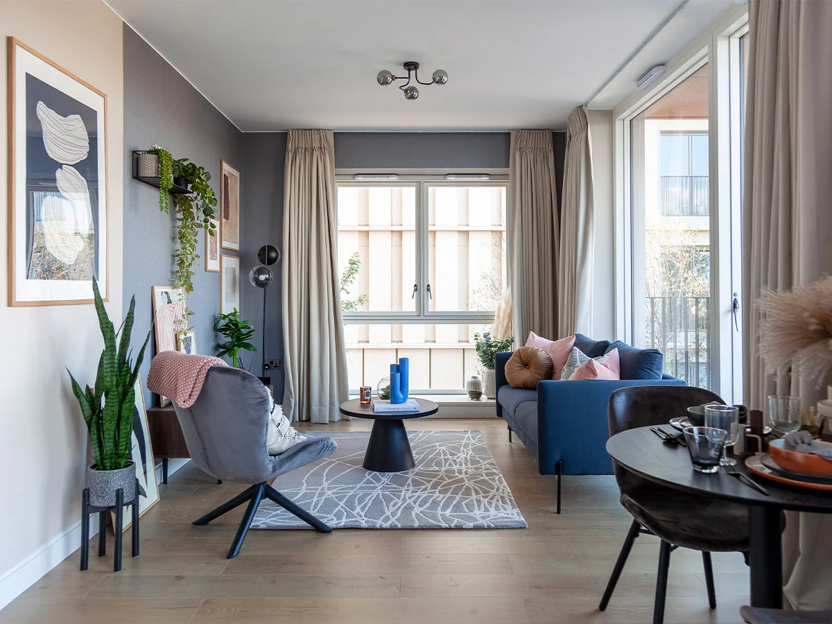 A chic arrangement of abstract art, a modern mirror, and decorative accents styled with thoughtfully curated show homes furniture