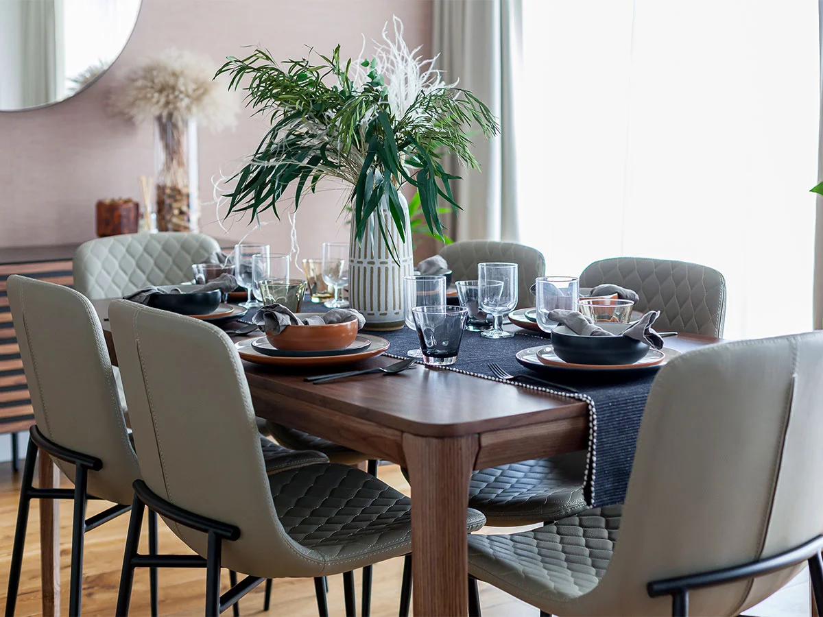 A chic arrangement of abstract art, a modern mirror, and decorative accents styled with thoughtfully curated show homes furniture