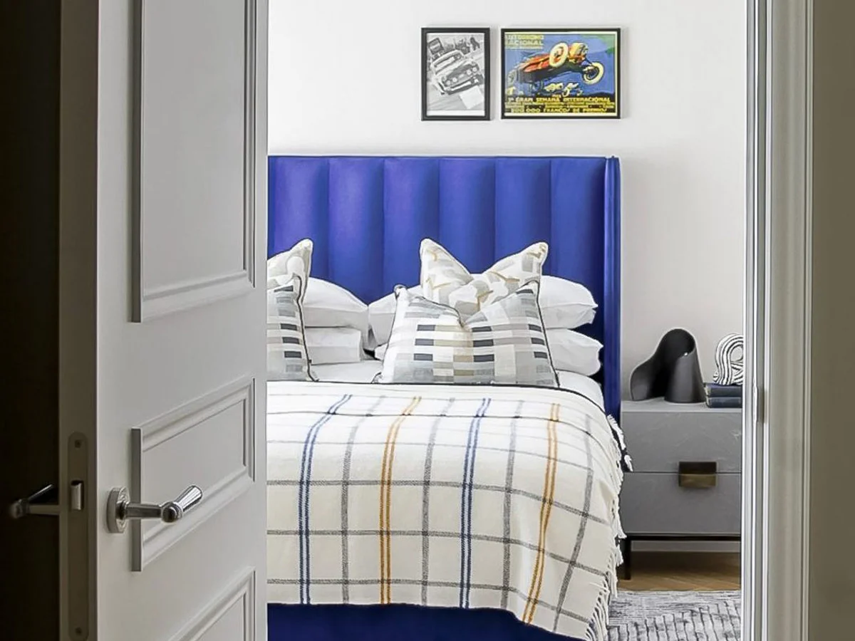 Open book with house photos, glasses, apples, pistachios, and stacked books on a table.