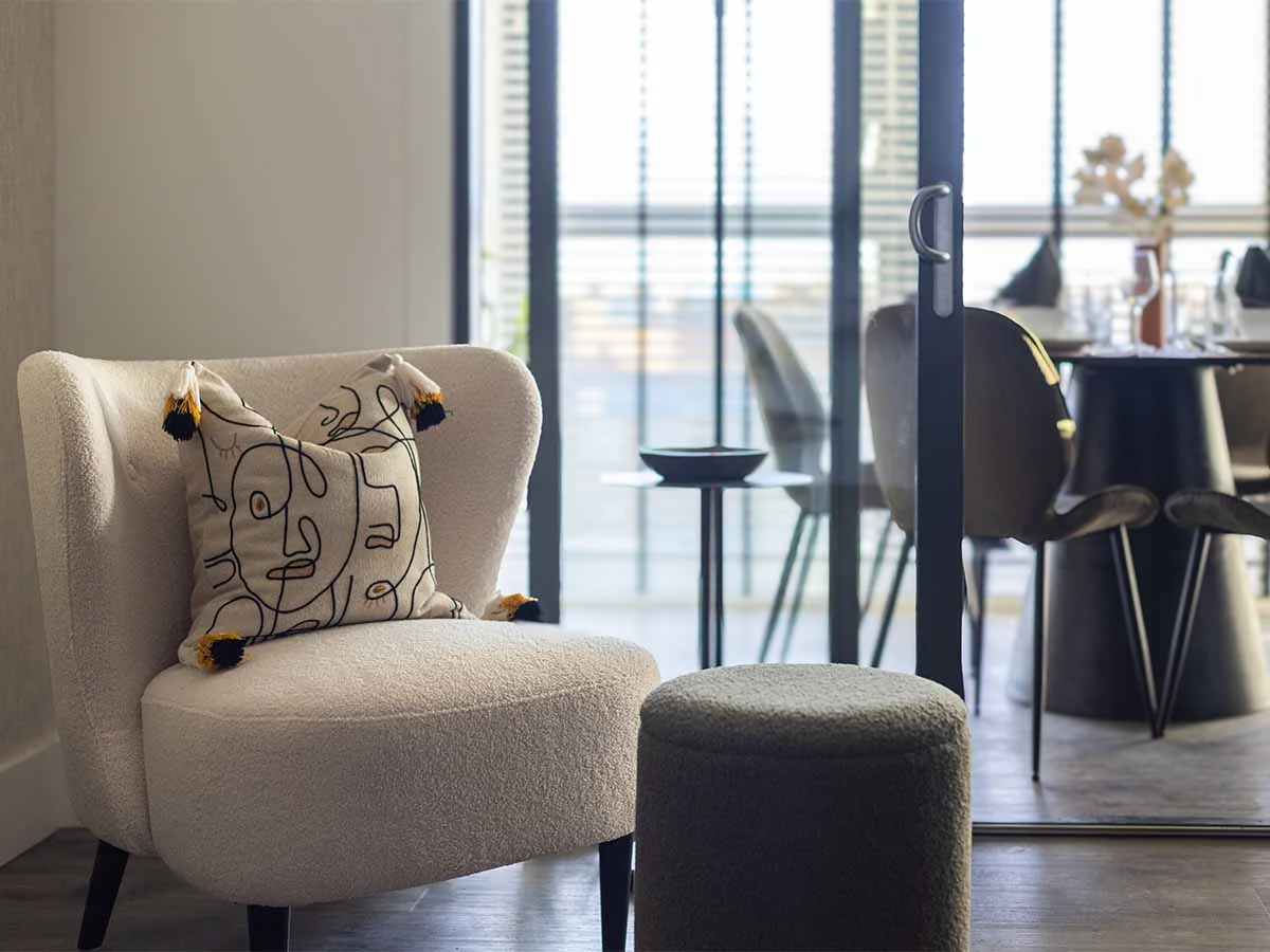Custom interior design with accent chair and balcony view in tailored furniture package London