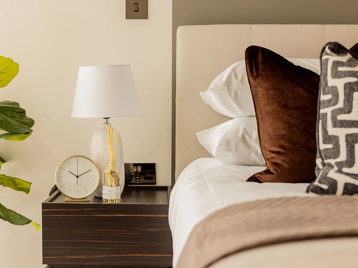 Modern bedroom interior design at White City London apartment with neutral tones and styled bedside