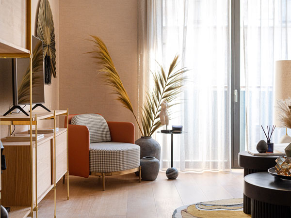 A cozy, sunlit living room with soft sheer drapes that gently filter the light—showcasing how elegant curtains in Dubai can transform a space