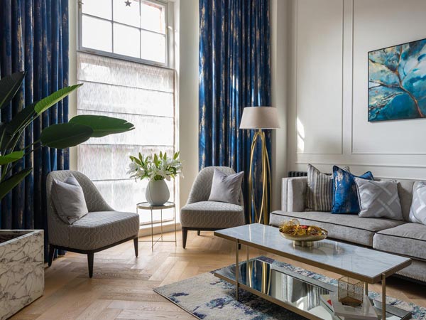 Luxurious London flat living room with blue velvet curtains, showcasing the high-impact InStyle Direct transformations