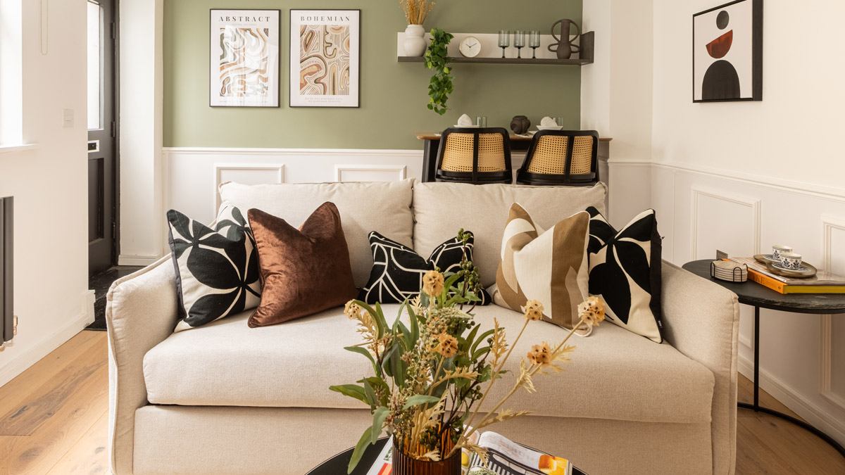 A beautifully curated Airbnb-ready living room with contemporary art, cozy seating, and natural textures, designed through a professional Airbnb furnishing service