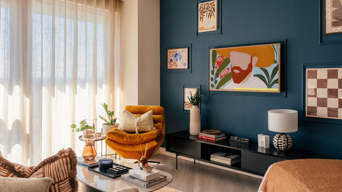 A Stylish furnished Dubai living room with a deep blue accent wall, eclectic artwork, a cozy mustard chair, and curated décor styling that highlights professional Furnishing Services Dubai