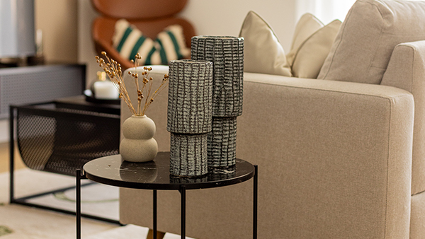 A chic living room vignette featuring a beige sofa and curated décor on a sleek black side table, capturing the refined aesthetic of premium furniture Dubai designs
