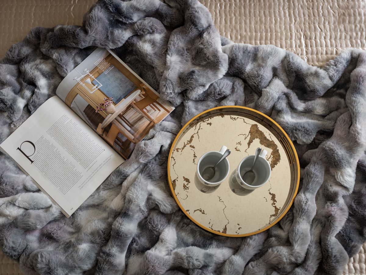 Detail of luxury styling with faux fur blanket and tray. Highlights quality of furnishing packages for overseas investors.
