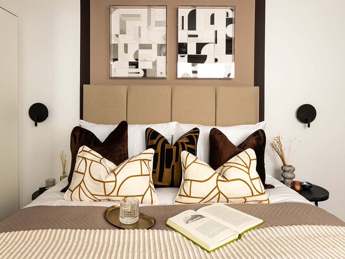 Elegant Dubai Airbnb bedroom setup with plush pillows, wall décor, and soft bedding