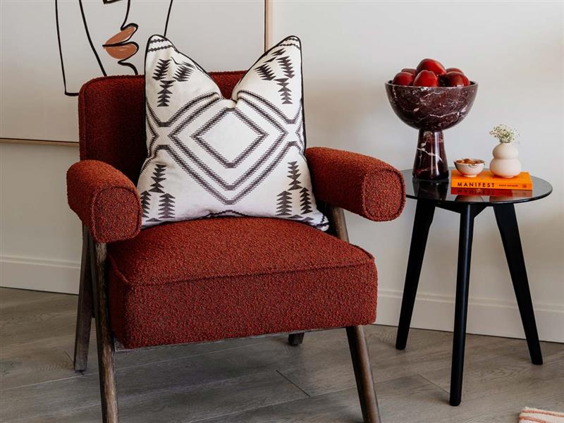 Designer accent chair and decor detail in a London flat, demonstrating the design impact to maximize rental appeal