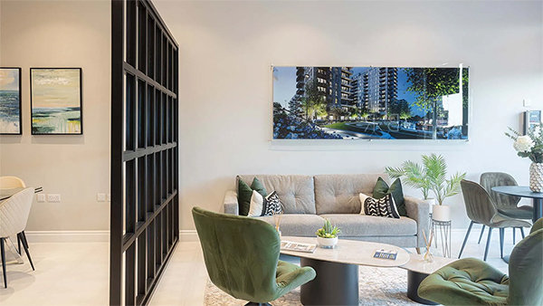 A refined lounge with soft neutrals, lush green chairs, and modern artwork—an inviting space shaped with thoughtful commercial interior design