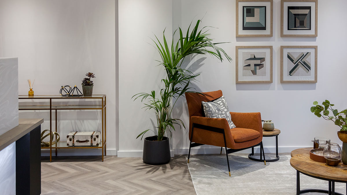 Statement armchair lounge – rental‑ready by InStyle Direct Modern lounge corner with rust armchair, tall plant and geometric art by InStyle Direct London