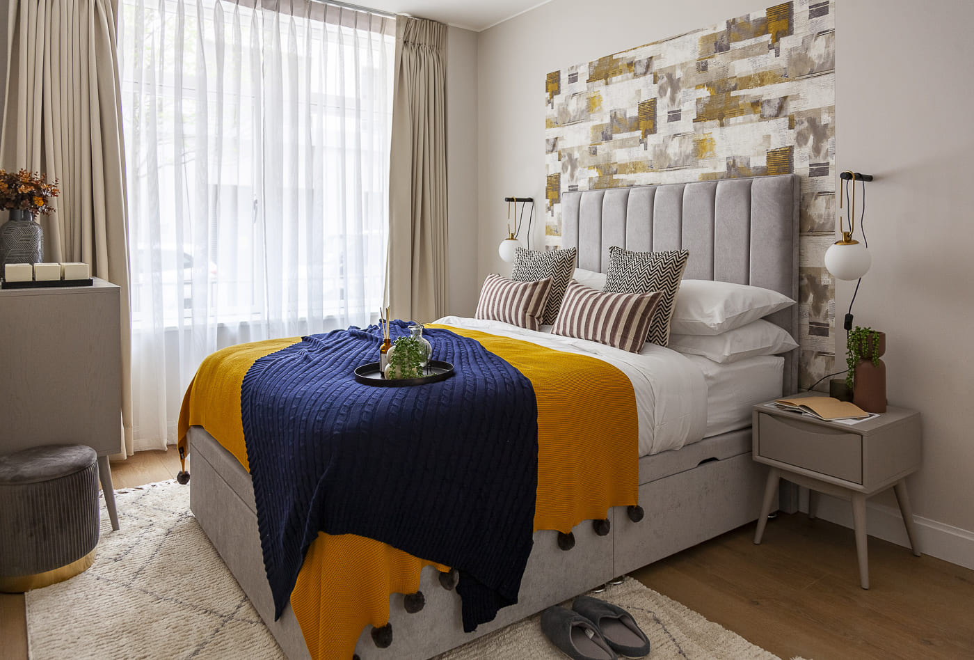 Furnishing Packages for Overseas Investors - Stylish London Flat Bedroom Stylish London flat bedroom with mustard and navy bedding, contemporary headboard, and accent wall.