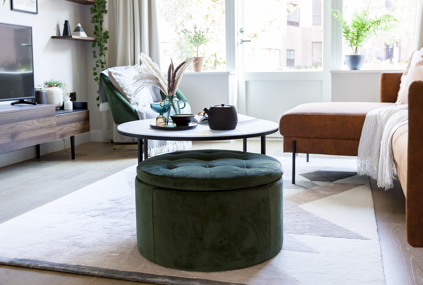 Professional Furnishing London Flat - Inviting Living Room Design Inviting London flat living room with a teal ottoman, comfortable sofa, and bright windows.